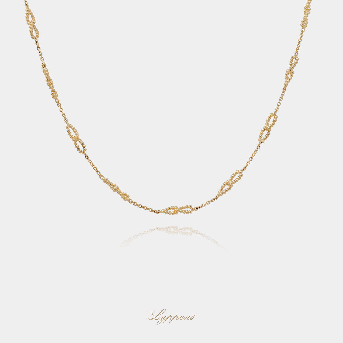 Geelgouden anker schakelcollier met fantasie bolletjes schakels.