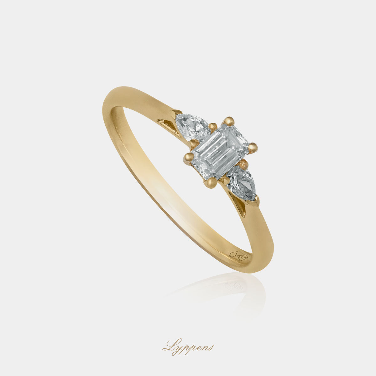Staande geelgouden driesteens verlovings ring gezet met emerald en peer geslepen diamant.