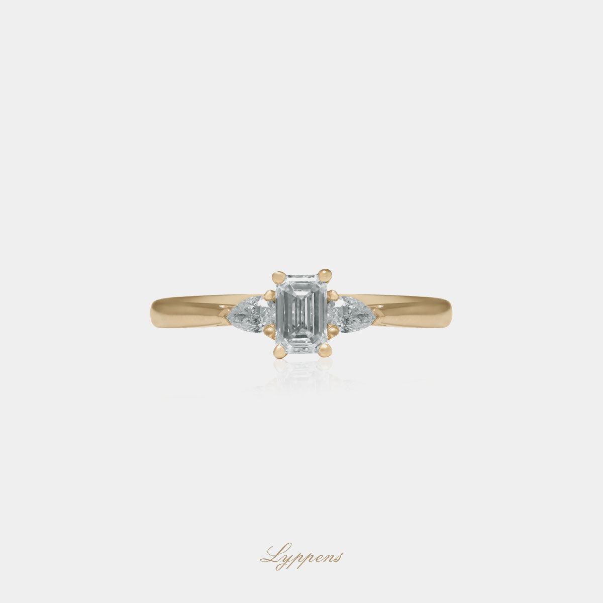 Geelgouden driesteens verlovings ring gezet met emerald en peer geslepen diamant.