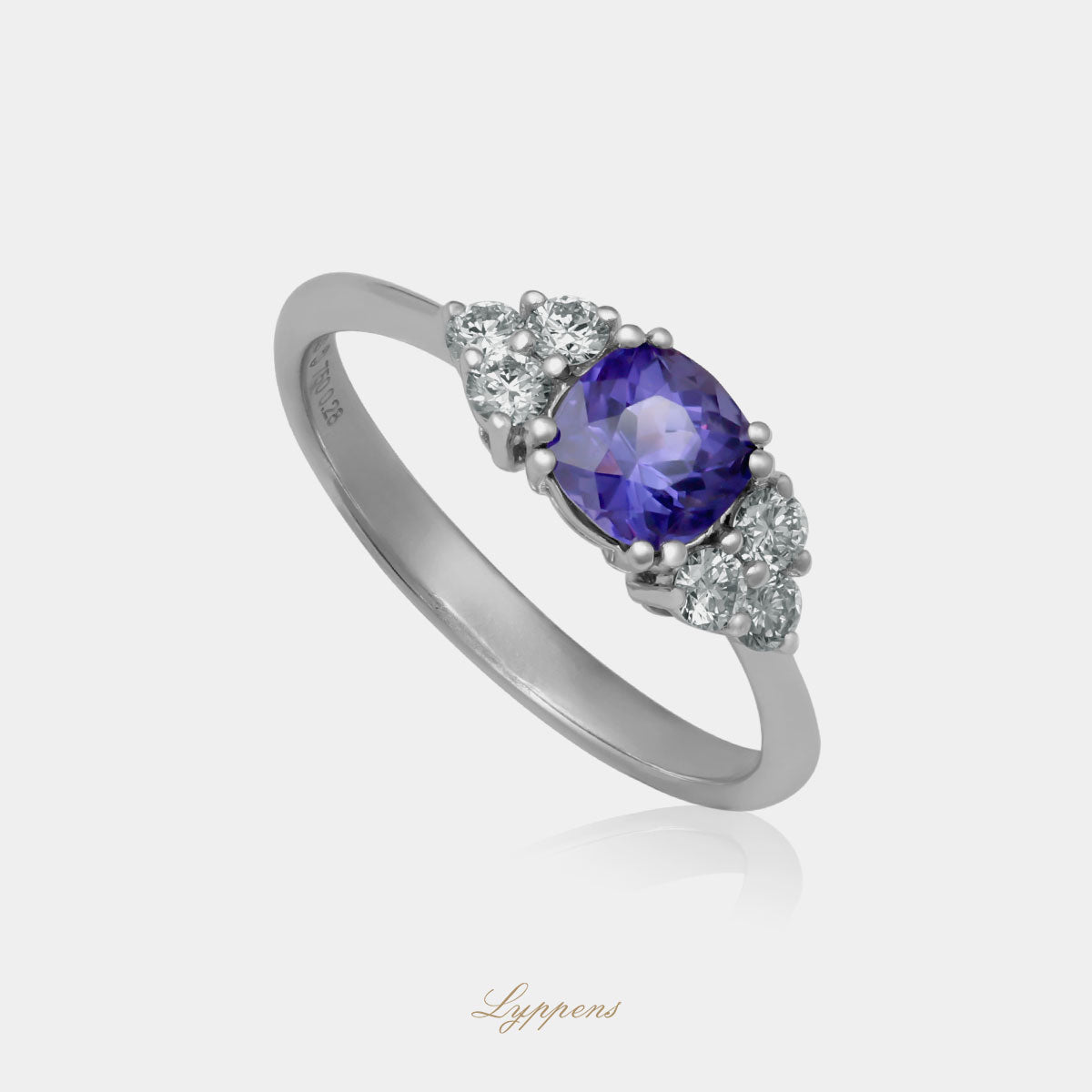 Witgouden ring in het midden gezet met een rond geslepen paarse saffier en geflankeerd door briljant geslepen diamant.