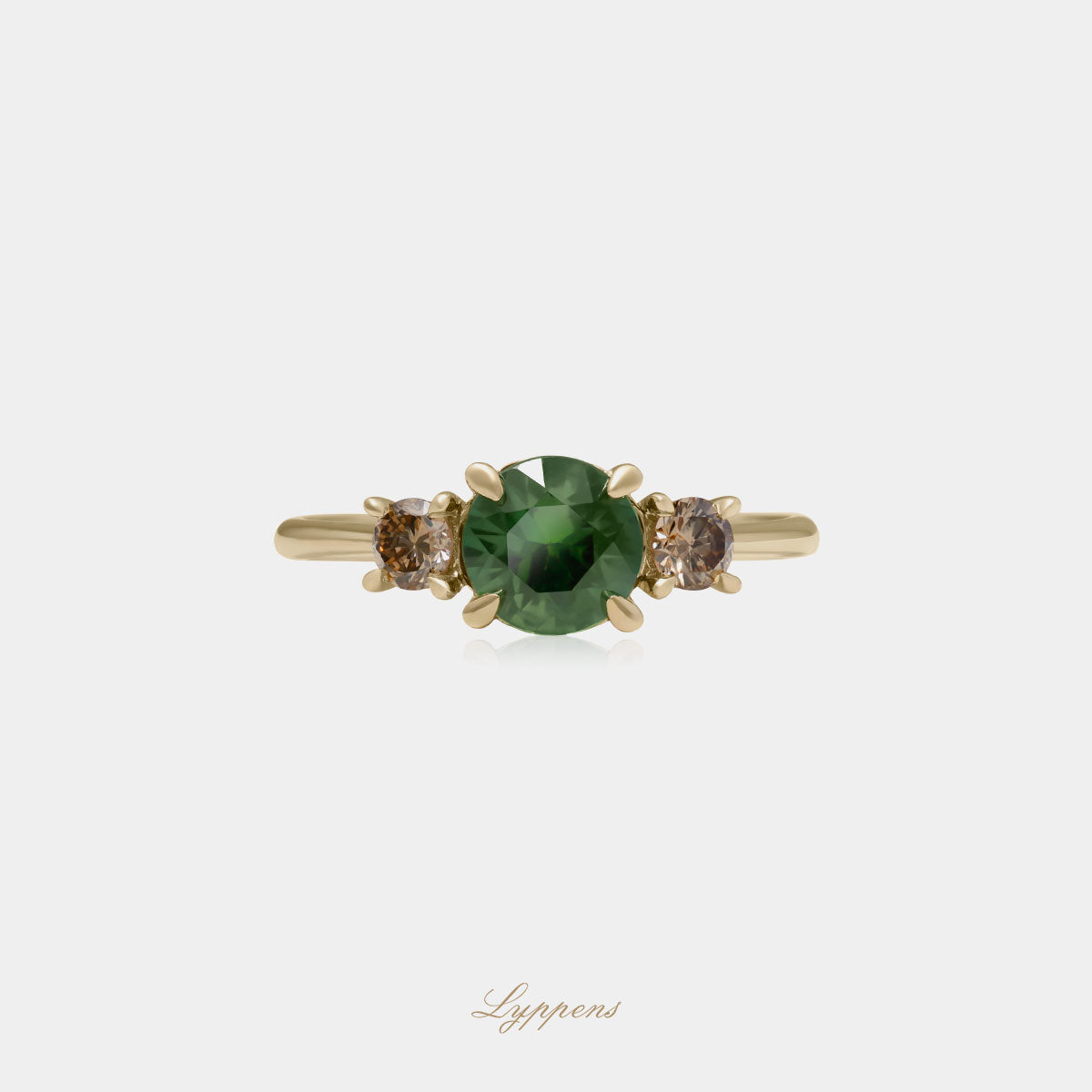 Geelgouden ring in het midden gezet met een rond geslepen groene saffier en geflankeerd door briljant geslepen bruine diamant.