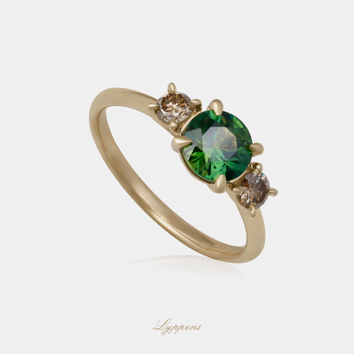 Geelgouden ring in het midden gezet met een rond geslepen groene saffier en geflankeerd door briljant geslepen bruine diamant.