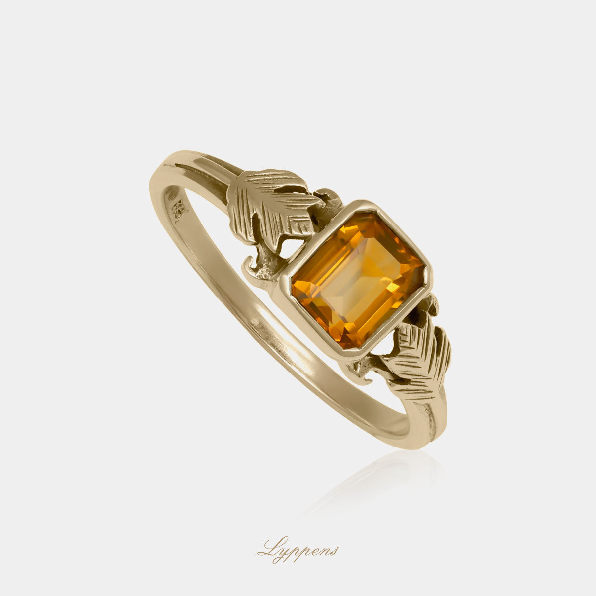 Geelgouden ring in het midden gezet met een rechthoekige citrien en aan weerzijde gedecoreerd met een blad.