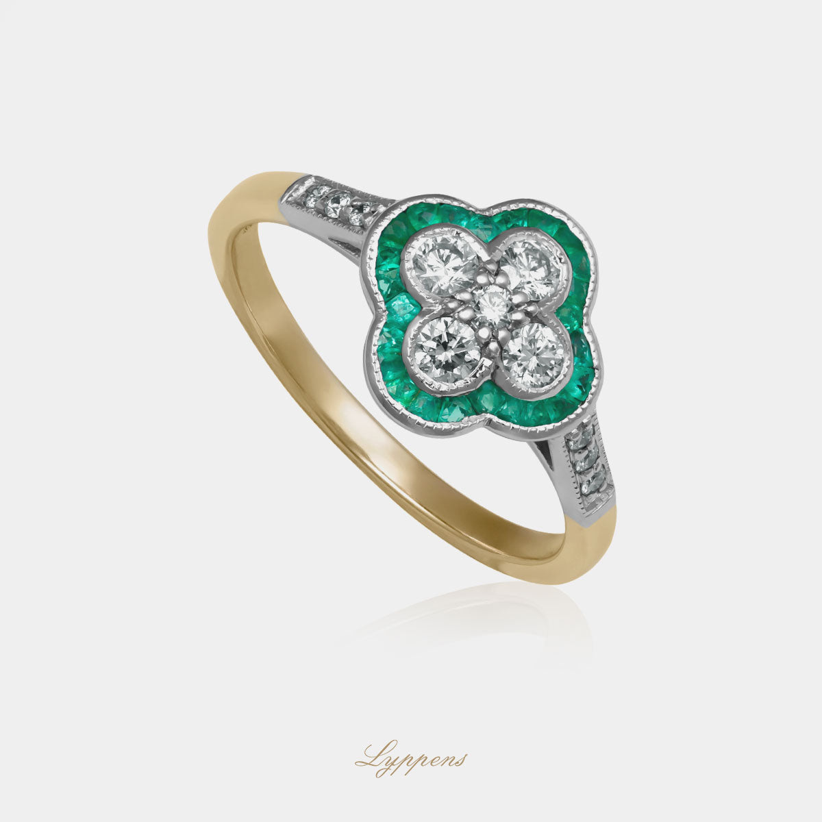 Geelgouden klaver vormige ring gezet met briljant geslepen diamant en smaragd.