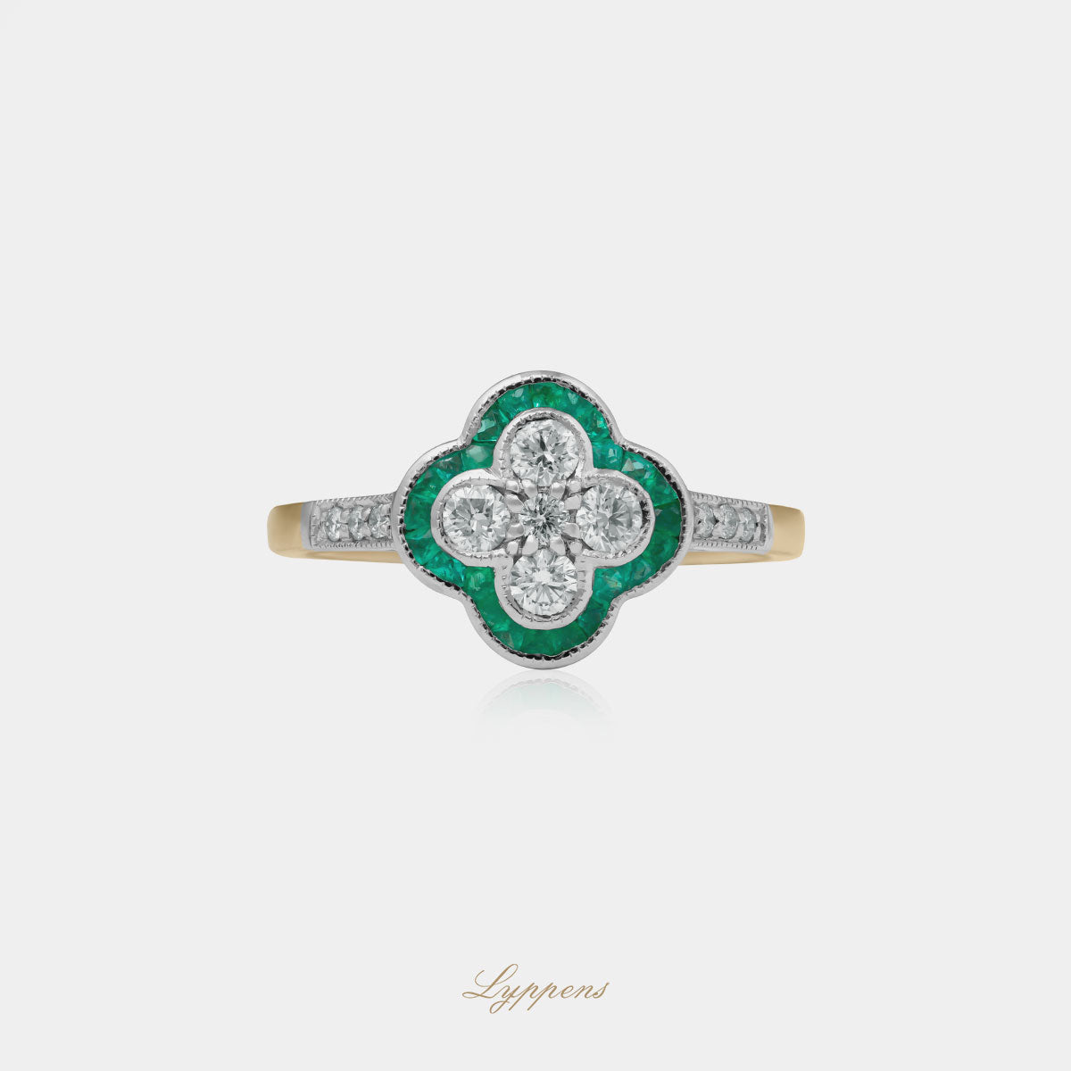 Geelgouden klaver vormige ring gezet met briljant geslepen diamant en smaragd.