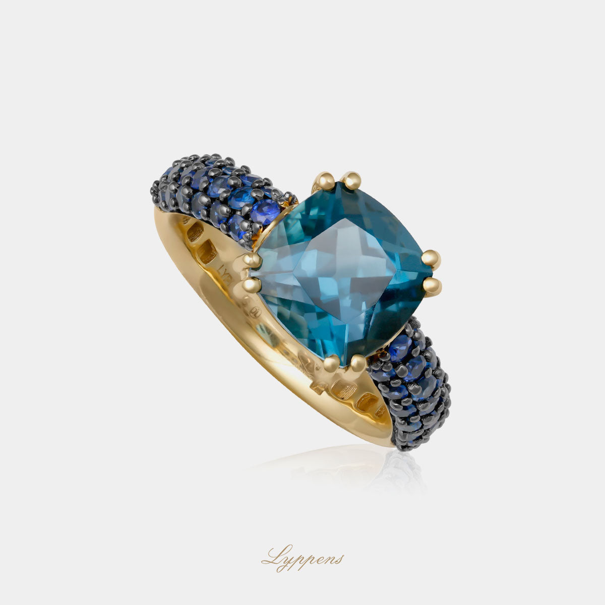 Geelgouden ring in het midden gezet met een kussen geslepen topaas en rond geslepen saffier.