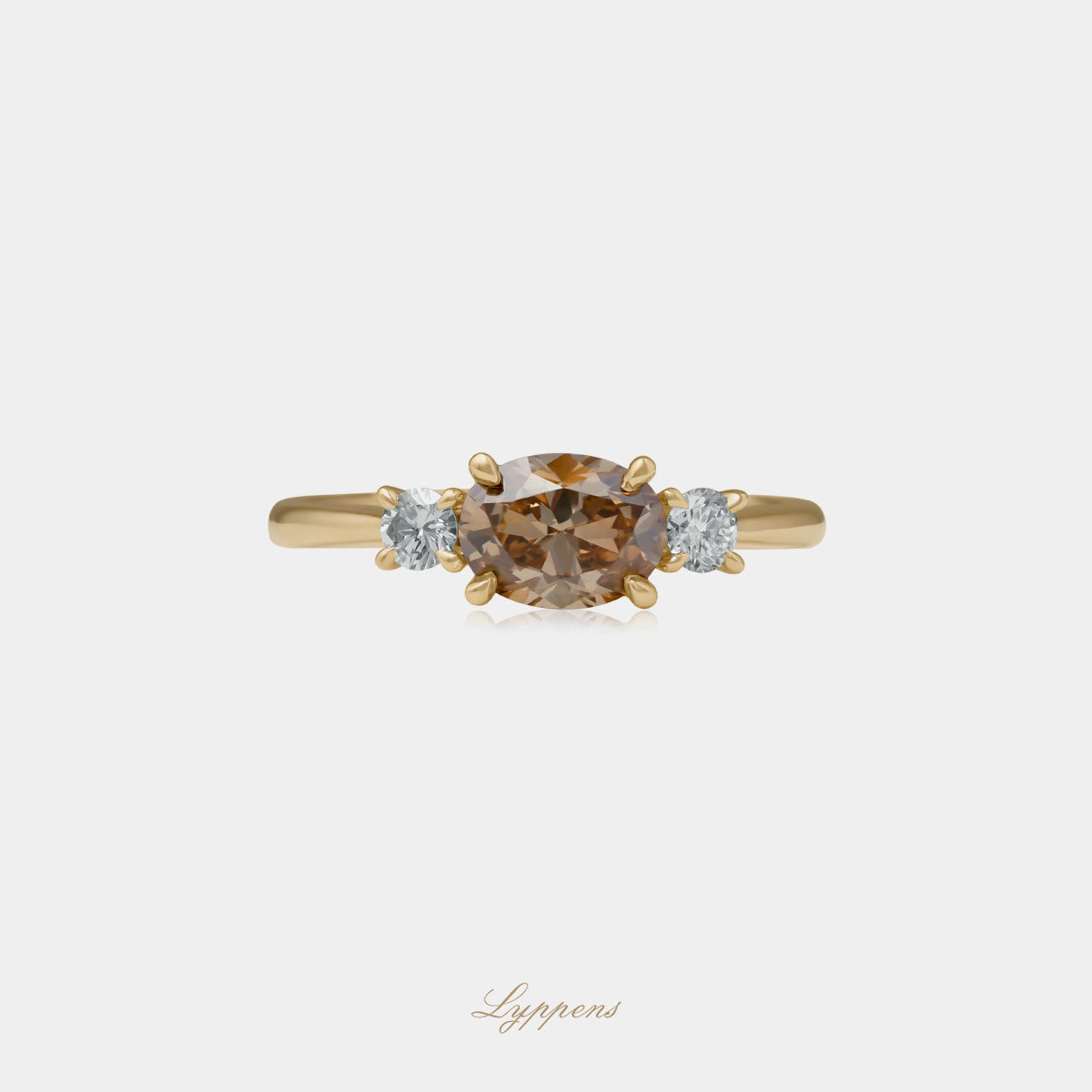 Geelgouden ring in het midden gezet met een ovaal geslepen bruine diamant geflankeerd door briljant geslepen witte diamant.