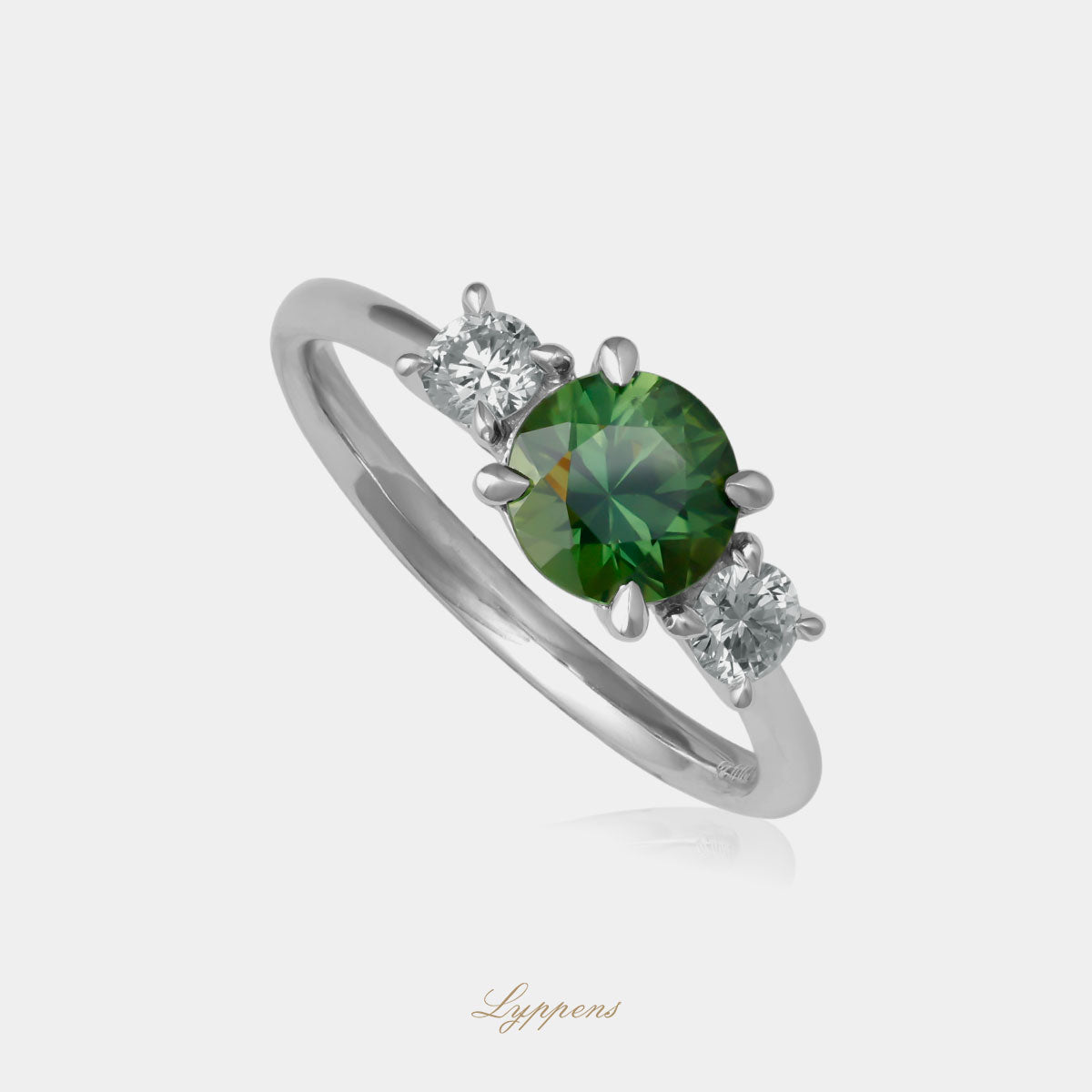 Witgouden ring in het midden gezet met een groene saffier geflankeerd door briljant geslepen diamant.