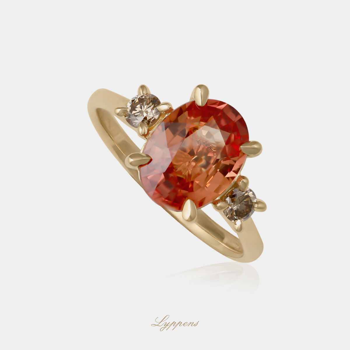 Geelgouden ring gezet met een ovaal geslepen oranje saffier en geflankeerd door briljant geslepen bruine diamant