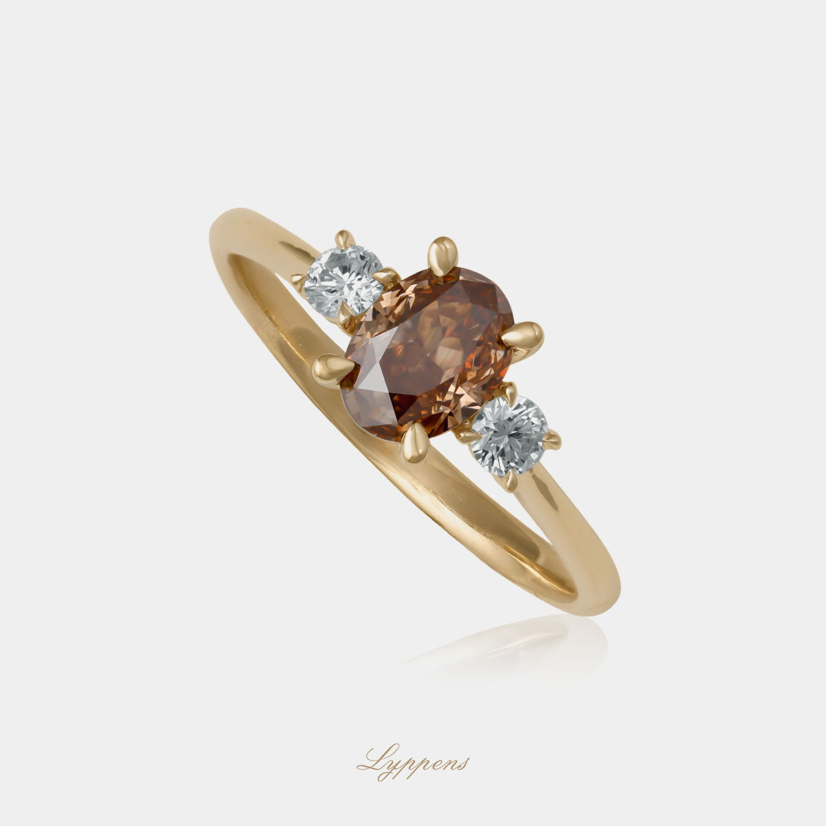 Geelgouden verlovingsring in het midden gezet met een ovale bruine diamant en geflankeerd door briljant geslepen diamant.