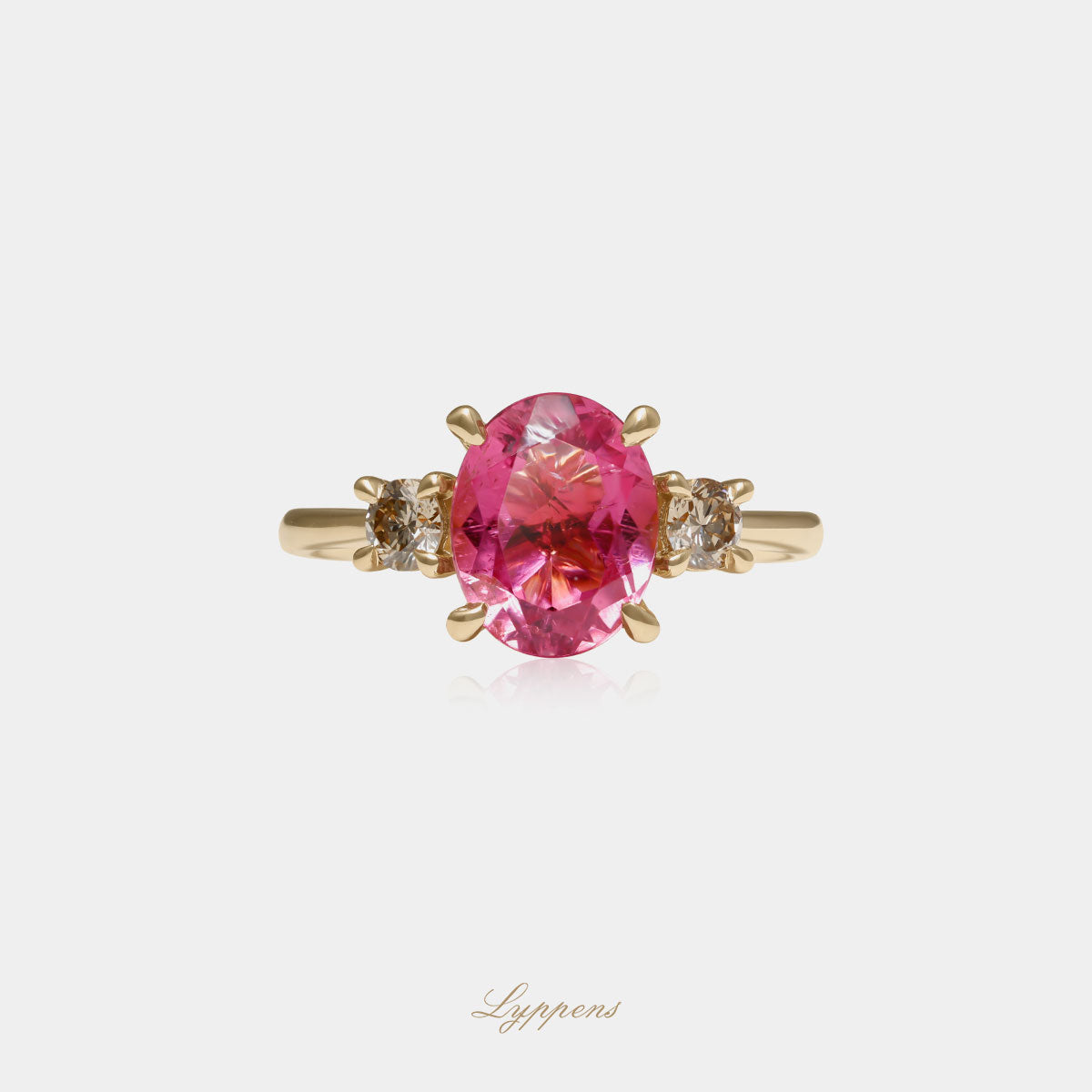 Geelgouden ring in het midden gezet met een roze toermalijn geflankeerd door briljant geslepen bruine diamant.