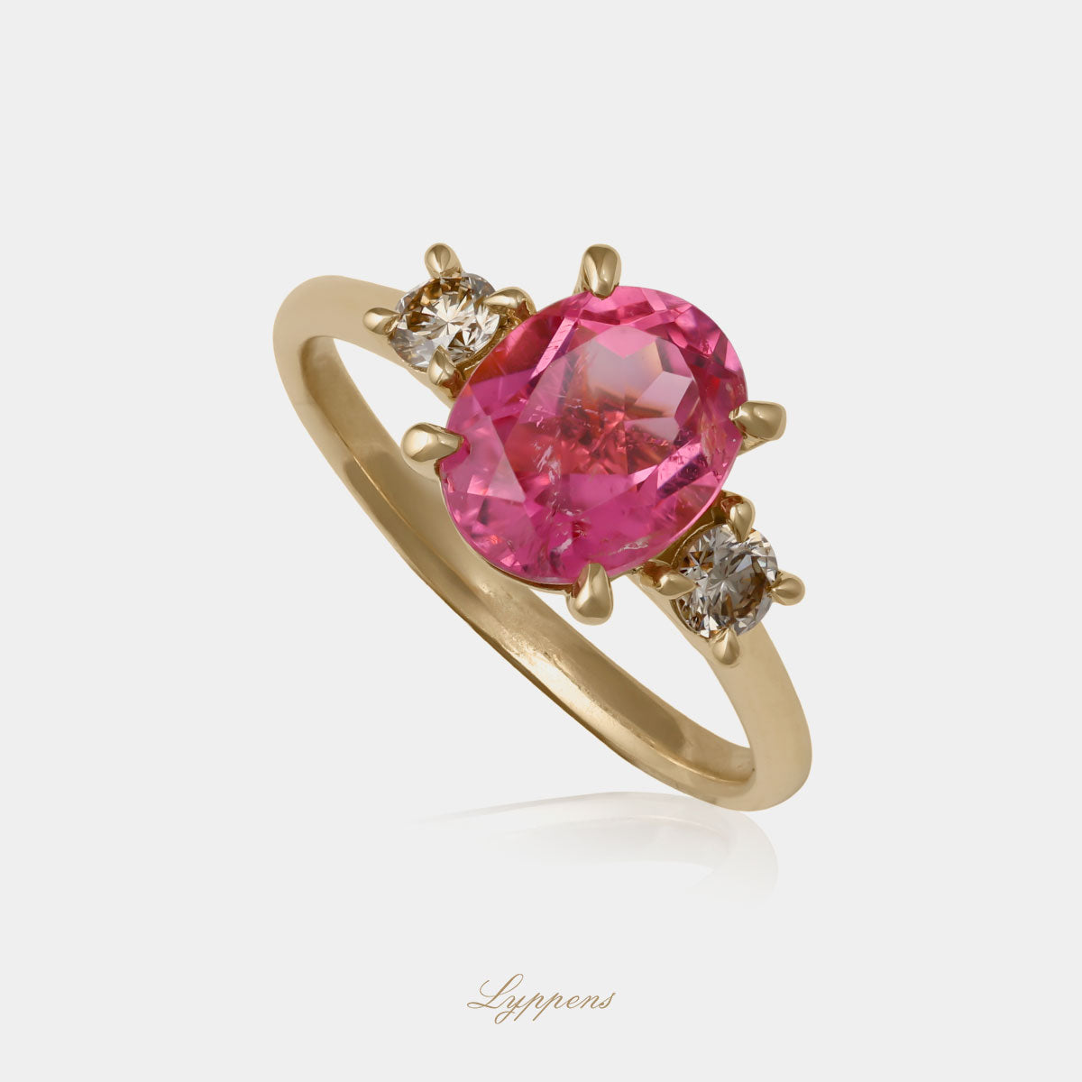 Geelgouden ring in het midden gezet met een roze toermalijn geflankeerd door briljant geslepen bruine diamant.