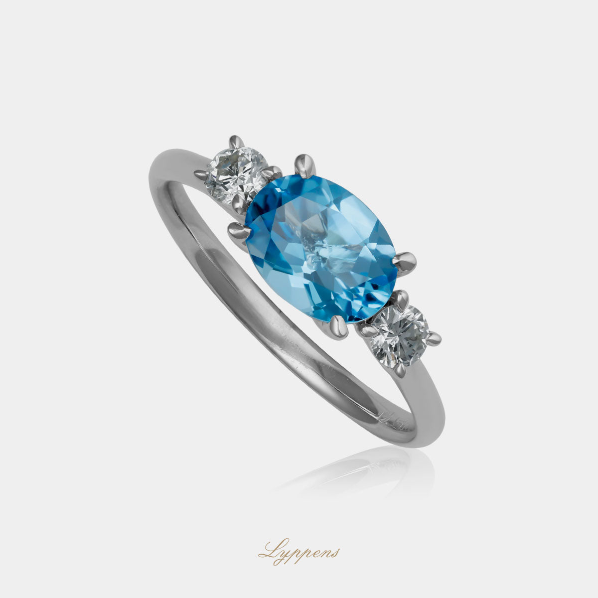 Witgouden ring in het midden gezet met een ovaal geslepen blauwe topaas geflankeerd door briljant geslepen diamant.