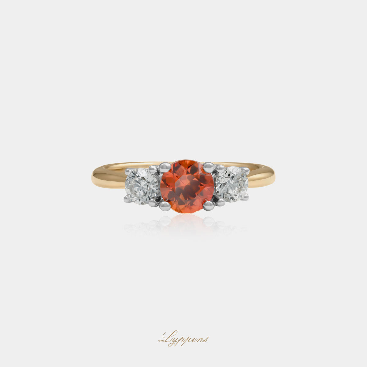 18kt geelgouden driesteens ring in het midden gezet met een oranje saffier geflankeerd door briljant geslepen diamant.