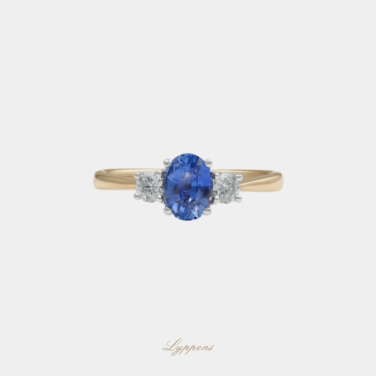 18kt geelgouden driesteens ring in het midden gezet met een ovaal geslepen saffier geflankeerd door briljant geslepen diamant.