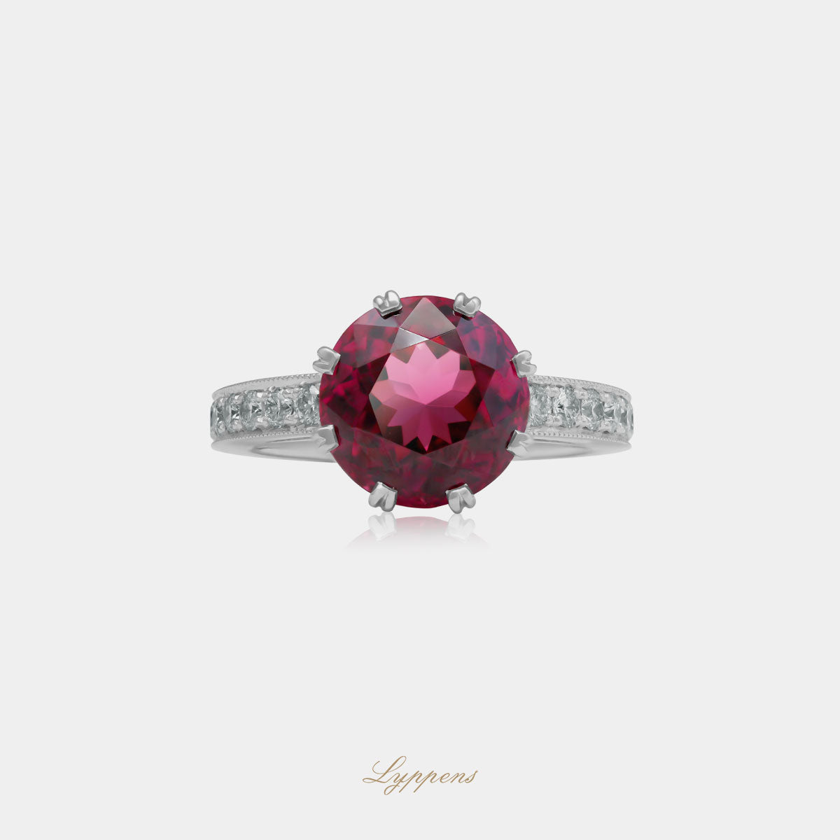 Witgouden vintage ring in het midden gezet met een rond geslepen rhodoliet en geflankeerd door briljant geslepen diamant.