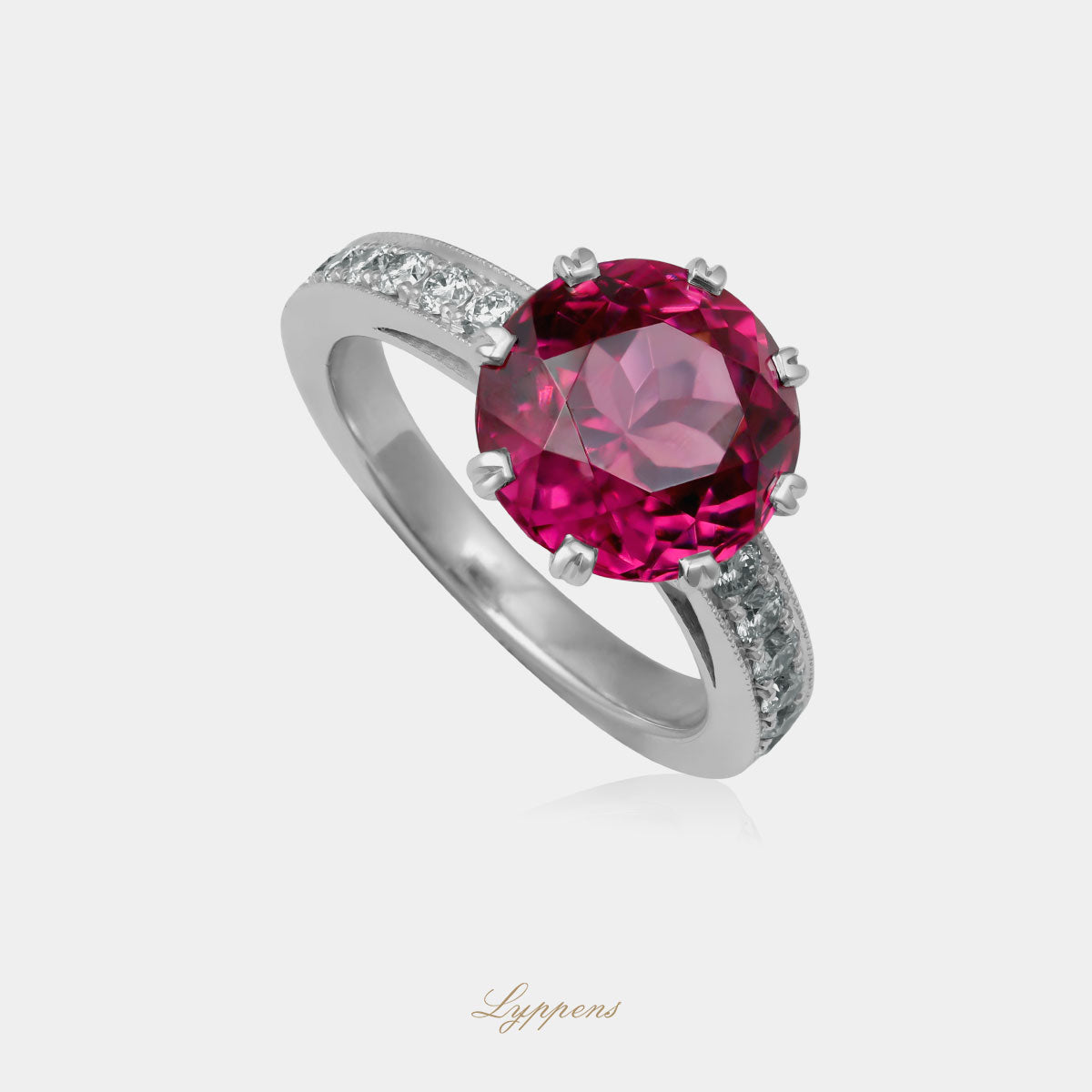 Witgouden vintage ring in het midden gezet met een rond geslepen rhodoliet en geflankeerd door briljant geslepen diamant.