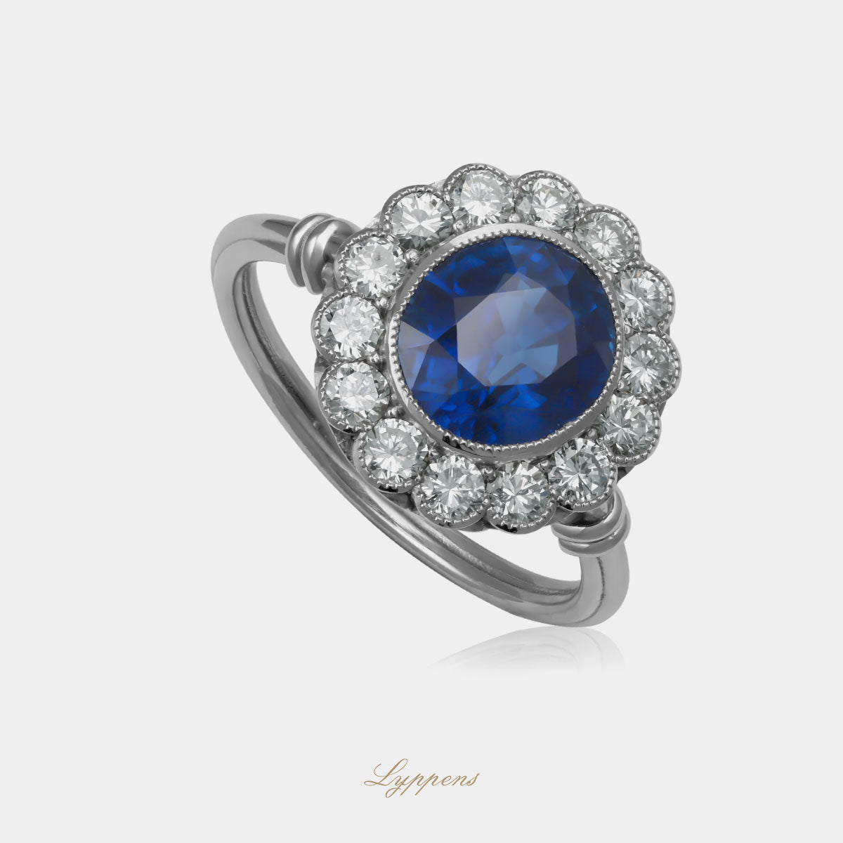 Witgouden verlovingsring van 18 karaat met een ovale blauwe saffier, omringd door een entourage van briljant geslepen diamanten