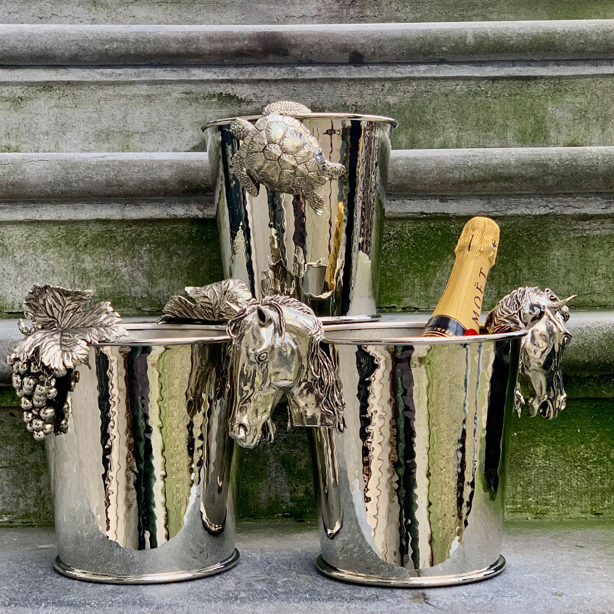 Zilveren flessen bakken gedecoreerd met een paard, druiven en een schildpad.