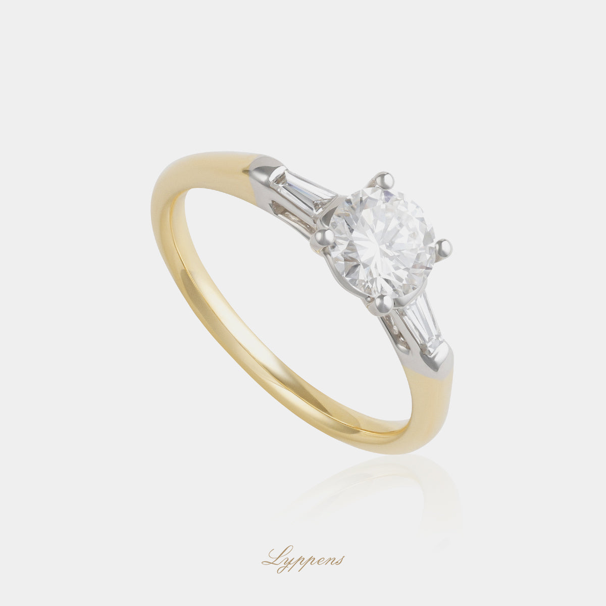 18 karaat geel- en witgouden diamanten ring met centrale briljant geslepen diamant van 0.79ct D VVS1, geflankeerd door tapered baguette geslepen diamanten