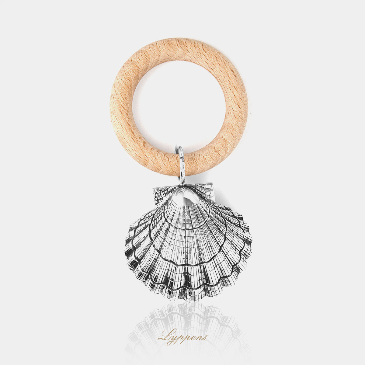 Eerste gehalte zilveren rammelaar in de vorm van een schelp.