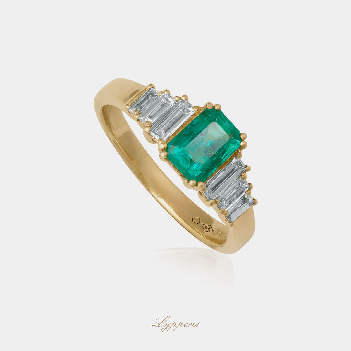 Staande geelgouden verlovings ring in het midden gezet met emerald geslepen smaragd en baguette geslepen diamant. 