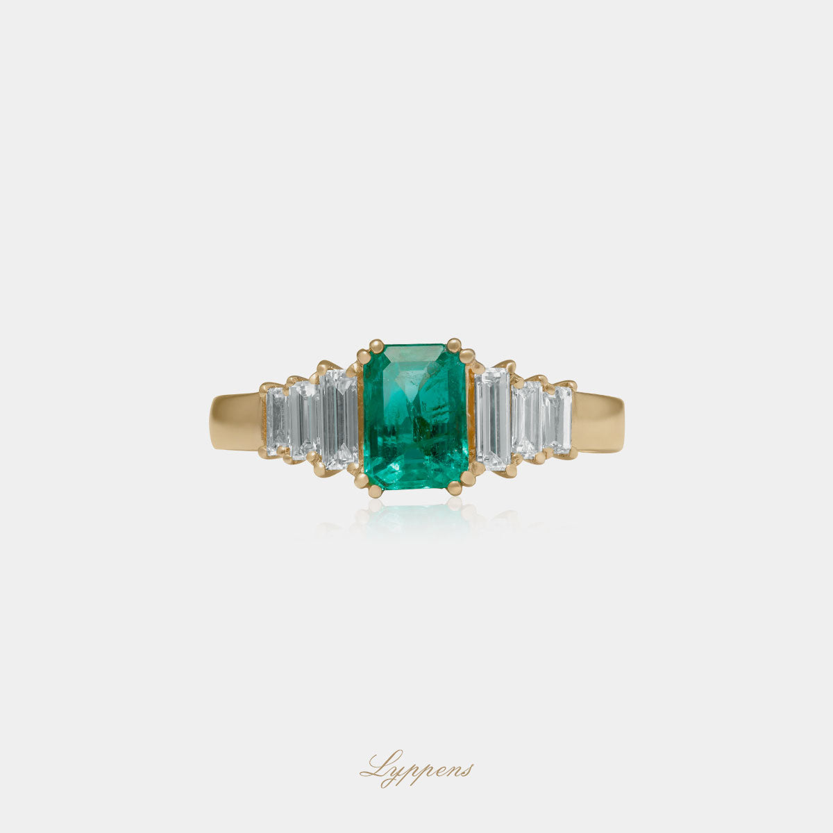 Geelgouden verlovings ring in het midden gezet met emerald geslepen smaragd en baguette geslepen diamant. 