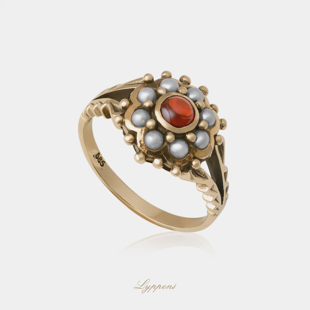 Geelgouden entourage ring in het midden gezet met granaat in een entourage van parels.
