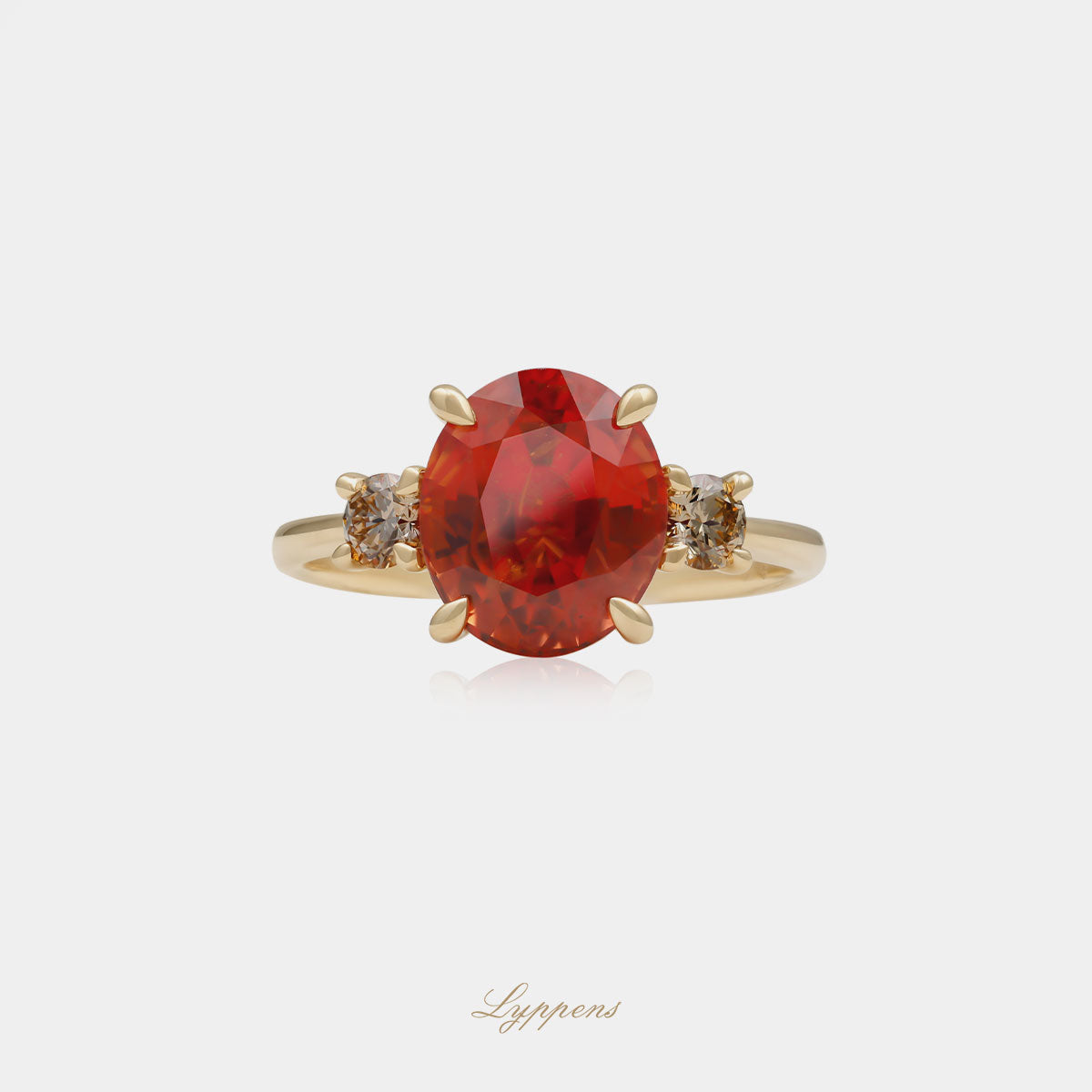 18kt geelgouden ring met ovaal geslepen oranje saffier als middensteen, geflankeerd door bruine briljant geslepen diamant van in totaal 0.28 karaat, zuiverheid SI.