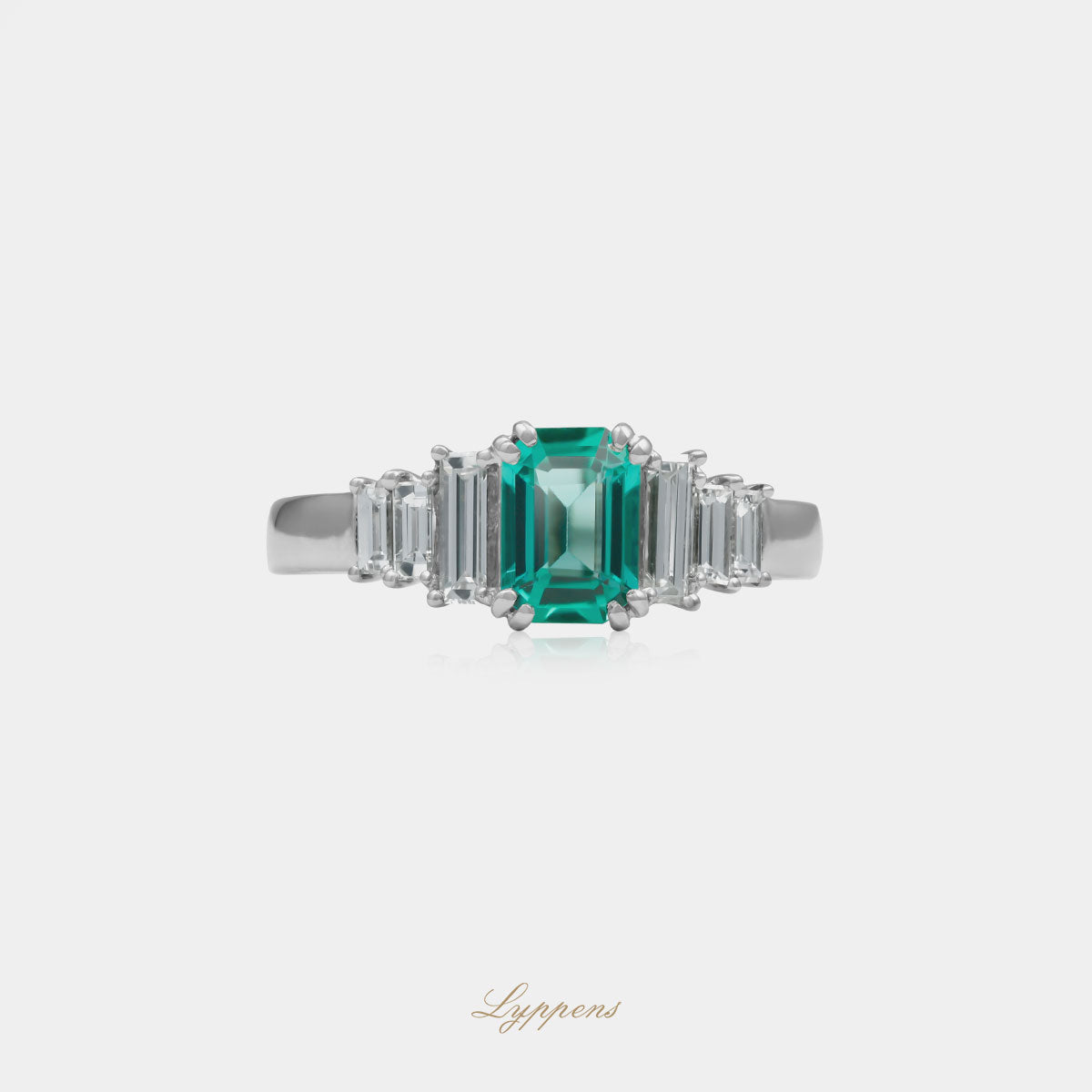 18kt witgouden ring met een emerald geslepen smaragd in het midden, geflankeerd door baguette geslepen diamanten, totaal 0.46ct, kleur F, zuiverheid VS1.