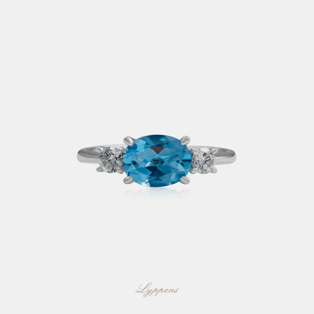 Witgouden ring in het midden gezet met een ovaal geslepen blauwe topaas geflankeerd door briljant geslepen diamant.