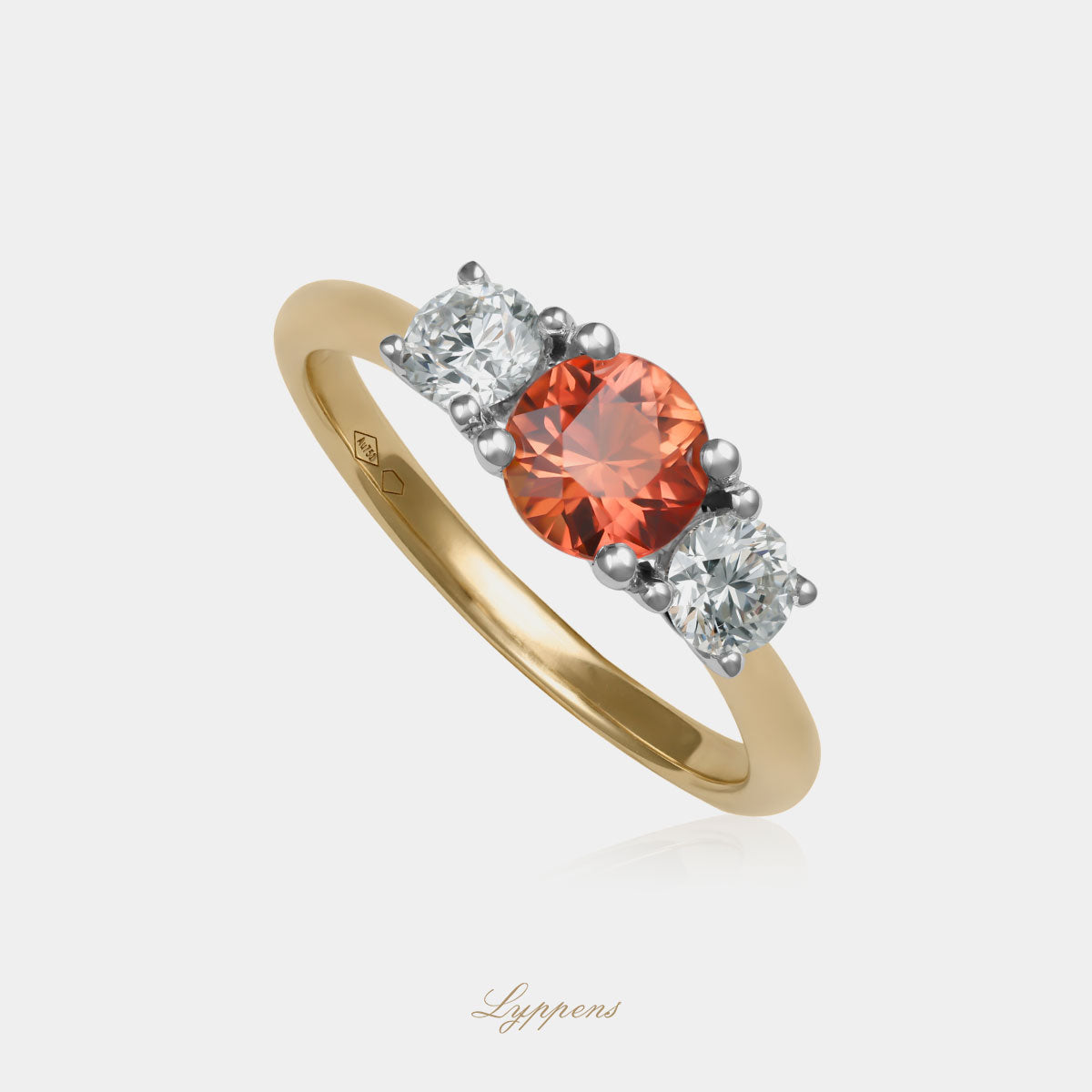 18kt geelgouden driesteens ring in het midden gezet met een oranje saffier geflankeerd door briljant geslepen diamant.