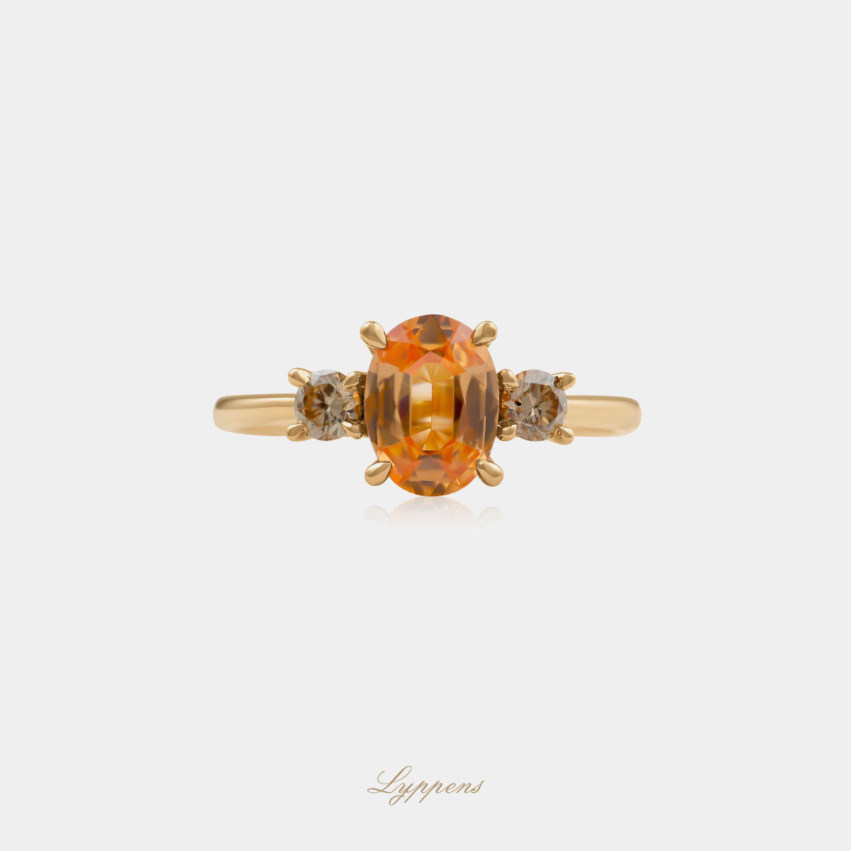 18kt geelgouden driesteens ring in het midden gezet met een ovaal geslepen granaat geflankeerd door briljant geslepen bruine diamant.