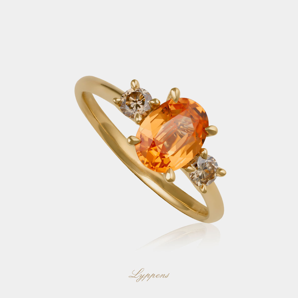 18kt geelgouden driesteens ring in het midden gezet met een ovaal geslepen granaat geflankeerd door briljant geslepen bruine diamant.