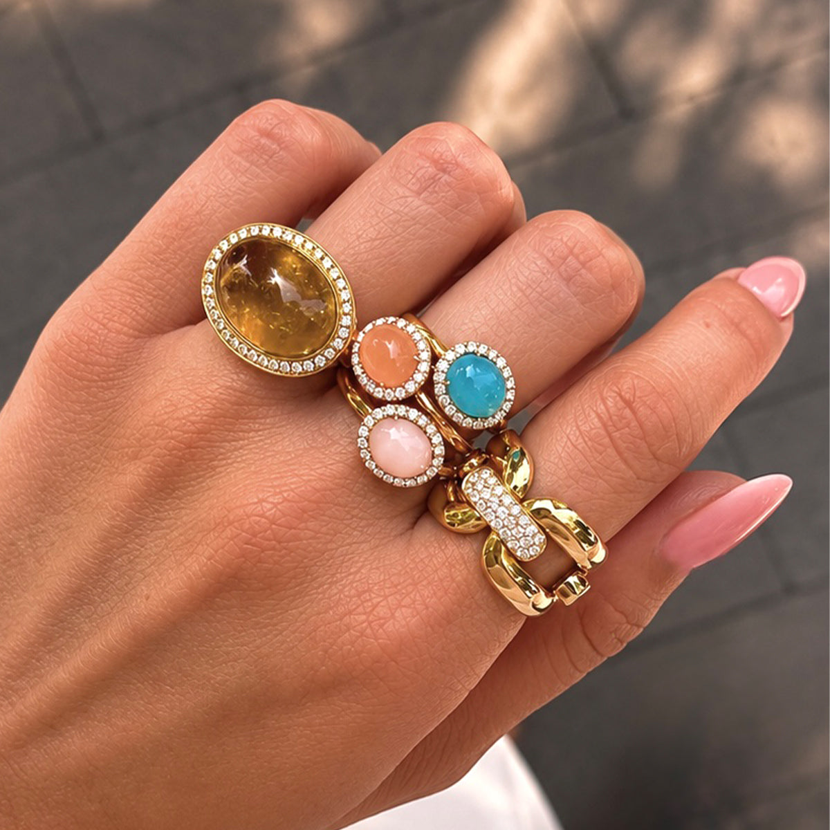 Hand vol met ringen met edelstenen en diamant.