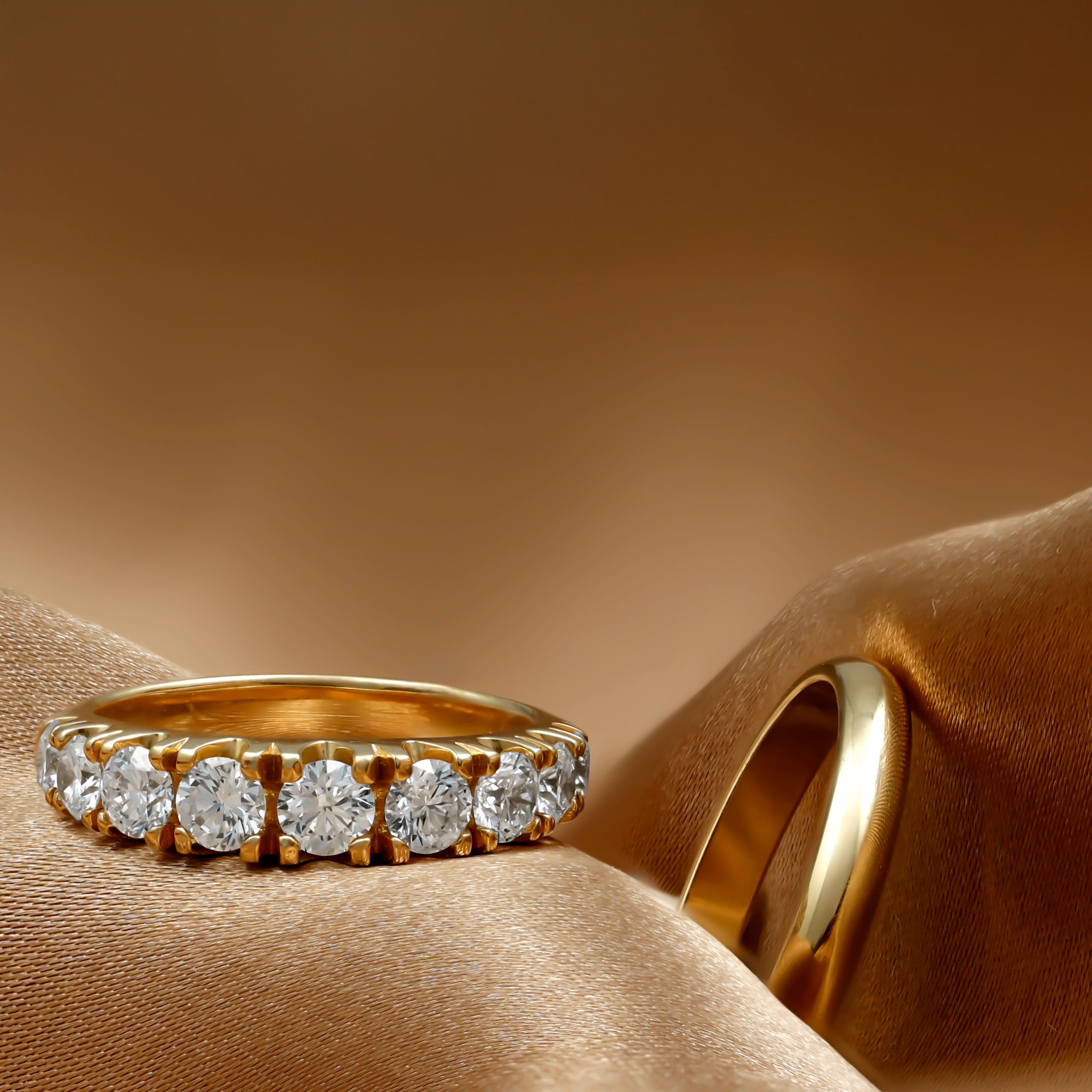 Tweepaar verlovingsringen, een glade band en een rijring met briljant geslepen diamant.