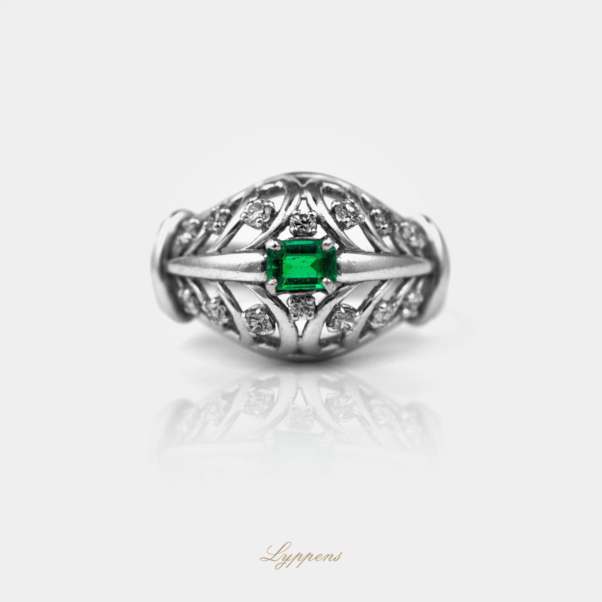 Liggende vintage ring met emerald geslepen smaragd en diamant.