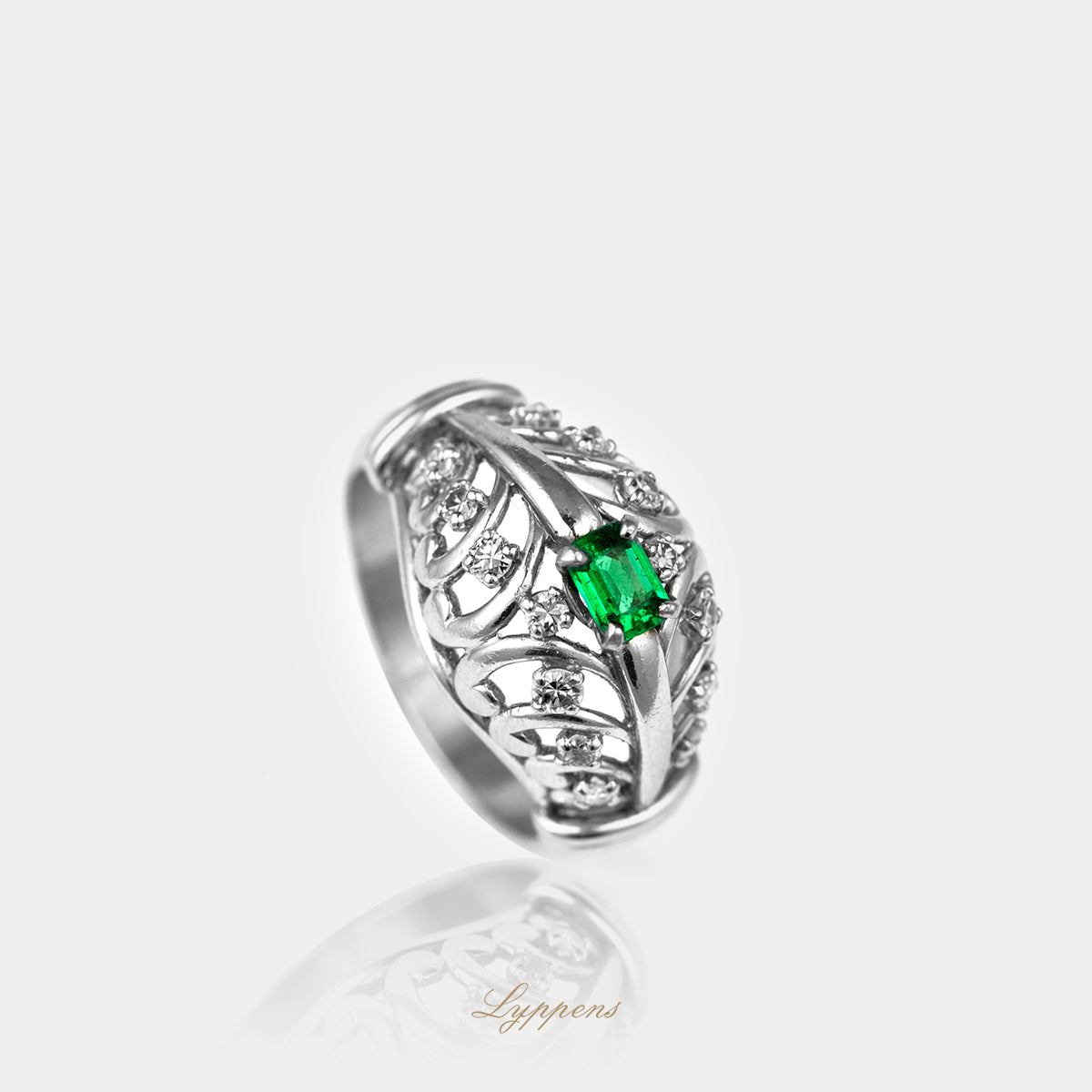Staande witgouden opengewerkte ring met smaragd en diamant.